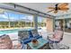 Inviting back porch featuring tile flooring, ceiling fan and lounge seating overlooking the pool at 23531 Dunstan Ave, Port Charlotte, FL 33954