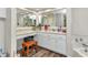 Bright bathroom vanity area with dual mirrors, drawers, and wooden stool at 23531 Dunstan Ave, Port Charlotte, FL 33954