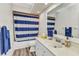 Bright bathroom featuring a blue and white striped shower curtain at 23531 Dunstan Ave, Port Charlotte, FL 33954