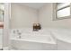 Clean white bathtub with tile surround and frosted glass window in bathroom at 23531 Dunstan Ave, Port Charlotte, FL 33954