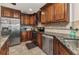 Kitchen boasts stainless steel appliances, granite countertops, tile backsplash, and wood cabinets at 23531 Dunstan Ave, Port Charlotte, FL 33954