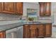 Kitchen sink area features stainless steel appliances, granite countertops, tile backsplash, and wood cabinets at 23531 Dunstan Ave, Port Charlotte, FL 33954
