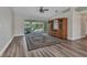 Bright living room with sliding glass doors to the pool area, wood-look floors, and a ceiling fan at 23531 Dunstan Ave, Port Charlotte, FL 33954