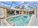 Inviting pool with blue tiled trim and steps for easy access, inside screened in enclosure at 23531 Dunstan Ave, Port Charlotte, FL 33954