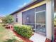 Side view of the screened lanai with outdoor seating and manicured landscaping at 2436 Arugula Dr, North Port, FL 34289