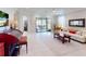 Bright living room with tile floors and access to a screened lanai provides ample space for entertaining at 2436 Arugula Dr, North Port, FL 34289