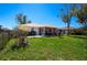 Expansive backyard featuring lush green grass, a screened porch, and mature trees at 27250 Salta Dr, Punta Gorda, FL 33983