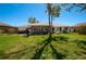 Backyard featuring green grass, a screened porch, and landscaping at 27250 Salta Dr, Punta Gorda, FL 33983
