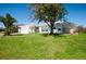 A serene single-story home with a two-car garage and lush green lawn, under a clear blue sky at 27250 Salta Dr, Punta Gorda, FL 33983
