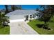 Aerial view of a well-maintained single-story home with a gray roof, a two-car garage and a concrete driveway at 27250 Salta Dr, Punta Gorda, FL 33983