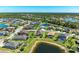 Expansive aerial view of the property nestled in a vibrant community, showcasing lush greenery and serene lakes at 2810 Sherman Oak Dr, North Port, FL 34289