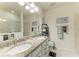 Well-lit bathroom with double vanity, granite countertops, a large mirror, and a walk-in shower at 2810 Sherman Oak Dr, North Port, FL 34289