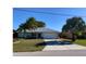 Charming single-story home with a well-manicured lawn and mature palm trees, showcasing curb appeal at 293 Broadmoor Ln, Rotonda West, FL 33947