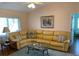 Comfortable living room with a large yellow sectional, area rug, and a relaxing ambiance at 293 Broadmoor Ln, Rotonda West, FL 33947