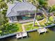 A view of the back of the home featuring a screened-in pool and dock with seating at 3812 Carupano Ct, Punta Gorda, FL 33950