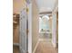 Hallway to a luxurious bathroom with a glass block window, a bathtub, and a closet with white doors at 3812 Carupano Ct, Punta Gorda, FL 33950