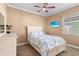 Cozy bedroom with a ceiling fan, TV, window and a comfortable bed with a blue patterned comforter at 3812 Carupano Ct, Punta Gorda, FL 33950