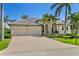 Beautiful home featuring manicured landscaping, mature palms, and a spacious circular driveway at 3812 Carupano Ct, Punta Gorda, FL 33950