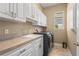 Well-equipped laundry room with cabinets, sink, countertop, and modern washer and dryer at 3812 Carupano Ct, Punta Gorda, FL 33950