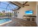 Screened in lanai featuring a pool, outdoor kitchen with built-in grill, and a television at 3812 Carupano Ct, Punta Gorda, FL 33950