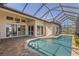 A screened-in pool area featuring a covered patio with a ceiling fan, offering a great view of the backyard at 3812 Carupano Ct, Punta Gorda, FL 33950