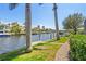 Lush landscaping lines the waterfront canal with a brick path on a sunny day at 3812 Carupano Ct, Punta Gorda, FL 33950