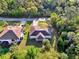 Aerial view highlighting home's roof, yard, screened lanai, driveway, and surrounding mature landscaping at 4221 Circleville St, North Port, FL 34286
