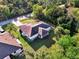 Aerial view showcases home with spacious yard, mature trees, screened lanai, and neutral roof at 4221 Circleville St, North Port, FL 34286