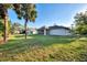 Expansive backyard with mature trees, lush green grass, landscaping and a screened in back porch at 4221 Circleville St, North Port, FL 34286