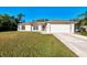 Welcoming single-story home with a two-car garage, a tidy lawn, and freshly painted exterior at 4221 Circleville St, North Port, FL 34286