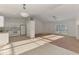 Kitchen with white cabinets, appliances, tile flooring, and adjacent carpeted living room at 4221 Circleville St, North Port, FL 34286