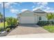 Well-maintained exterior features an attached garage, complemented by a paved driveway and professionally landscaped greenery at 43914 Blue Heron Ln, Punta Gorda, FL 33982