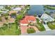 Aerial view of a waterfront property featuring a home with a red-tiled roof, lush landscaping, and an attached garage at 480 Macedonia Dr, Punta Gorda, FL 33950