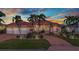 Stunning home exterior boasting lush landscaping, vibrant sunset skies, an attached three-car garage, and a red-tiled roof at 480 Macedonia Dr, Punta Gorda, FL 33950
