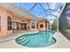 Inviting covered outdoor pool with a unique shape and elegant design featuring tile accents and clear enclosure at 480 Macedonia Dr, Punta Gorda, FL 33950