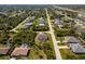 Charming single-story home with screened-in lanai and lush landscaping in quiet residential neighborhood from an aerial view at 7014 Baylor Street, Englewood, FL 34224