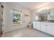 Bright bathroom featuring a vanity, toilet, window, tile flooring, and decorative accents at 7014 Baylor Street, Englewood, FL 34224