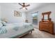 Cozy bedroom with a ceiling fan, dresser and comfortable bed offers a relaxing retreat at 7014 Baylor Street, Englewood, FL 34224