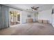 Large bedroom with neutral carpet, ceiling fan, and sliding doors to the outside at 7014 Baylor Street, Englewood, FL 34224