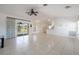 Open-concept living room with tile floors, ceiling fan, and sliding doors to the lanai at 7014 Baylor Street, Englewood, FL 34224