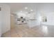 Open-concept living area featuring tiled floors, white walls, and a modern kitchen with bright lighting at 7014 Baylor Street, Englewood, FL 34224