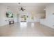 Bright living room featuring vaulted ceilings, tile flooring, and access to the backyard at 7014 Baylor Street, Englewood, FL 34224