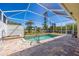 Inviting screened-in pool and spa featuring a brick paver deck and a serene outdoor living space at 7014 Baylor Street, Englewood, FL 34224