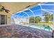 Inviting, screened-in lanai with a small pool, brick flooring, and a ceiling fan at 7014 Baylor Street, Englewood, FL 34224