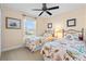 Bright bedroom features two twin beds, neutral paint and decor, and a ceiling fan at 721 Dania Ct, Punta Gorda, FL 33950