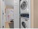 Efficient laundry setup featuring a stacked washer and dryer, plus easy access to an adjacent bathroom at 721 Dania Ct, Punta Gorda, FL 33950