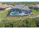 Aerial view of a home with a screened-in pool and lanai area, nestled in a lush community at 8774 Mystic Cir, North Port, FL 34287