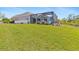 Manicured lawn in the backyard leads up to a screened-in lanai, enhancing outdoor enjoyment at 8774 Mystic Cir, North Port, FL 34287