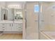 Bathroom featuring a glass enclosed shower and double sinks with sleek white cabinetry at 8774 Mystic Cir, North Port, FL 34287