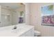 The bright bathroom features a large mirror, a white vanity, and a window with blinds at 8774 Mystic Cir, North Port, FL 34287